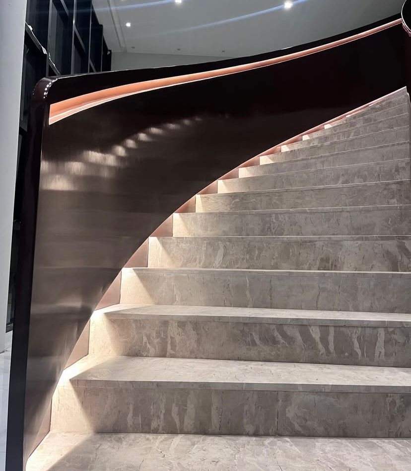 Escada curva iluminada em ambiente de pé-direito alto